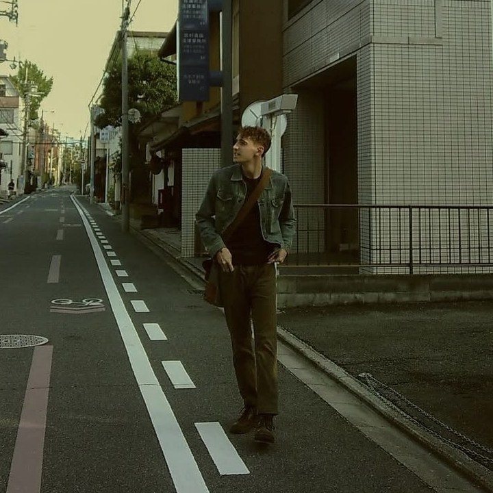 Bryan walking down a quiet street lined with power lines